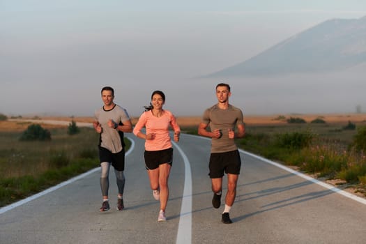 A group of friends, athletes, and joggers embrace the early morning hours as they run through the misty dawn, energized by the rising sun and surrounded by the tranquil beauty of nature.