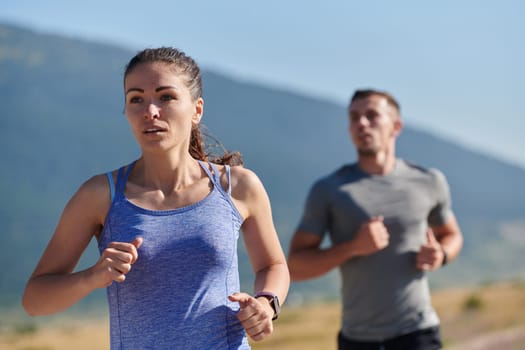 A couple runs through a sun-dappled road, their bodies strong and healthy, their love for each other and the outdoors evident in every stride.