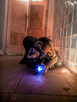 Cosplay of a stalker lying on the floor of an abandoned house in a plague doctor mask and holding a mysterious artifact. art photo