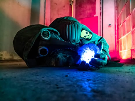 Cosplay of a stalker lying on the floor of an abandoned house in a plague doctor mask and holding a mysterious artifact. art photo