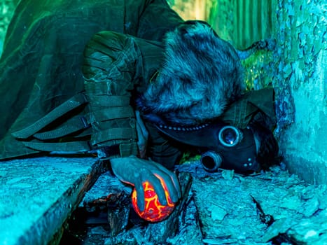 Cosplay of a stalker lying on the floor of an abandoned house in a plague doctor mask and holding a mysterious artifact. art photo