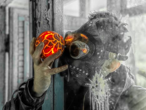 Cosplay of a stalker in a plague doctor mask holding a mysterious artifact and looking at it through glass