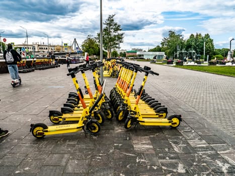 Parking for electric scooters on the square next to Gorky Park City electric scooter rental - kick sharing. Scooters standing in a special city parking lot. Moscow Russia 2023