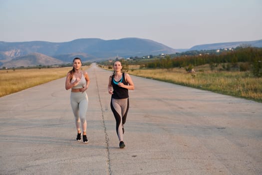 On a beautiful sunny day, two athletic friends enjoy a run together, maintaining their healthy lifestyle and fitness regimen.