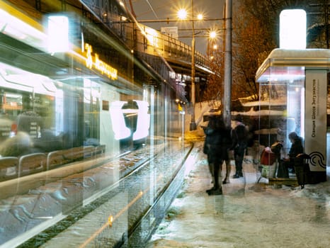 the tram leaves the stop in night city, motion blur view. Moscow Russia