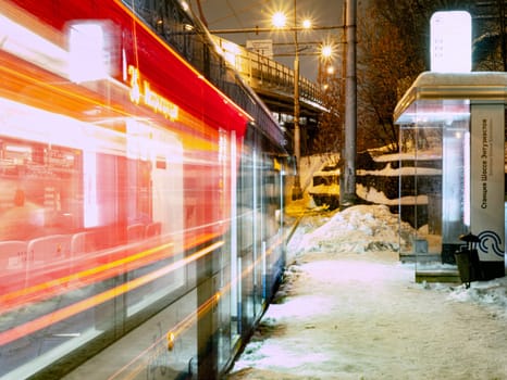 the tram leaves the stop in night city, motion blur view. Moscow Russia