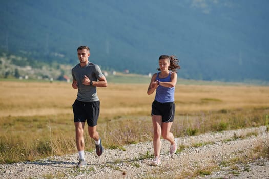 A couple runs through a sun-dappled road, their bodies strong and healthy, their love for each other and the outdoors evident in every stride.