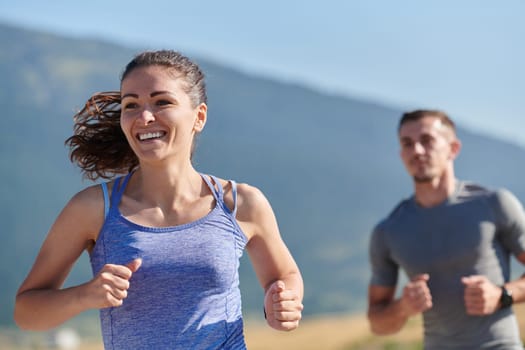 A couple runs through a sun-dappled road, their bodies strong and healthy, their love for each other and the outdoors evident in every stride.