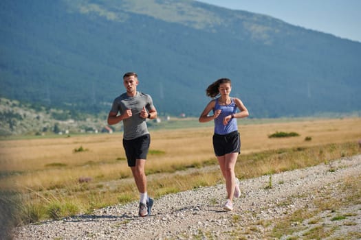 A couple runs through a sun-dappled road, their bodies strong and healthy, their love for each other and the outdoors evident in every stride.