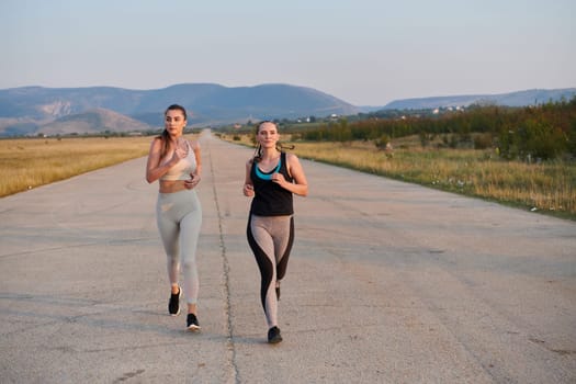 On a beautiful sunny day, two athletic friends enjoy a run together, maintaining their healthy lifestyle and fitness regimen.