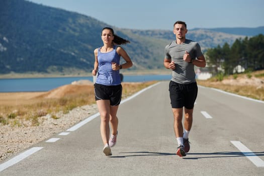 A couple runs through a sun-dappled road, their bodies strong and healthy, their love for each other and the outdoors evident in every stride.