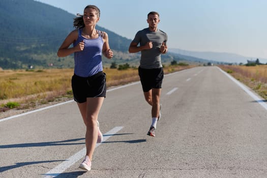 A couple runs through a sun-dappled road, their bodies strong and healthy, their love for each other and the outdoors evident in every stride.