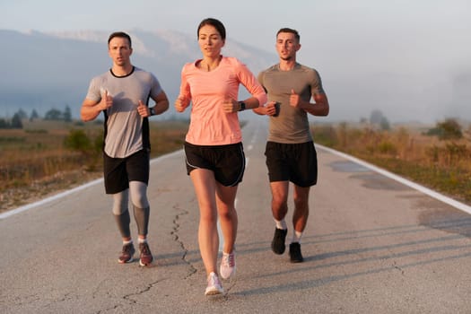 A group of friends, athletes, and joggers embrace the early morning hours as they run through the misty dawn, energized by the rising sun and surrounded by the tranquil beauty of nature.