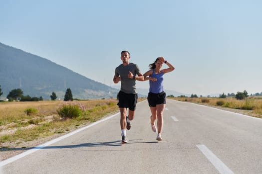 A couple runs through a sun-dappled road, their bodies strong and healthy, their love for each other and the outdoors evident in every stride.