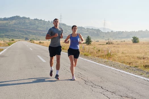 A couple runs through a sun-dappled road, their bodies strong and healthy, their love for each other and the outdoors evident in every stride.