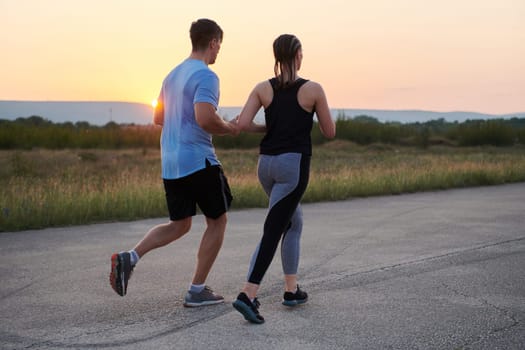 A diverse group of runners finds motivation and inspiration in each other as they train together for an upcoming competition, set against a breathtaking sunset backdrop.