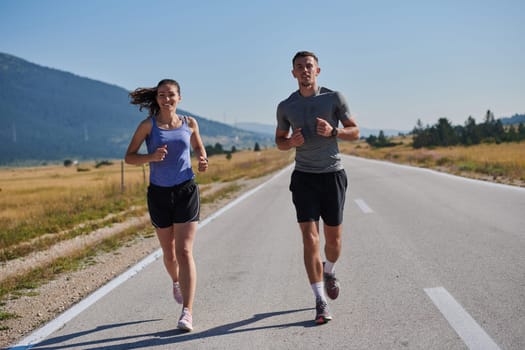 A couple runs through a sun-dappled road, their bodies strong and healthy, their love for each other and the outdoors evident in every stride.