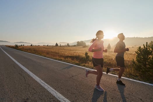 A couple runs through a sun-dappled road, their bodies strong and healthy, their love for each other and the outdoors evident in every stride.