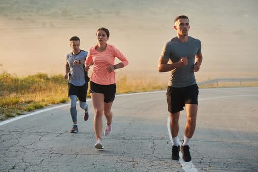 A group of friends, athletes, and joggers embrace the early morning hours as they run through the misty dawn, energized by the rising sun and surrounded by the tranquil beauty of nature.