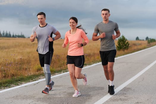 A group of friends, athletes, and joggers embrace the early morning hours as they run through the misty dawn, energized by the rising sun and surrounded by the tranquil beauty of nature.