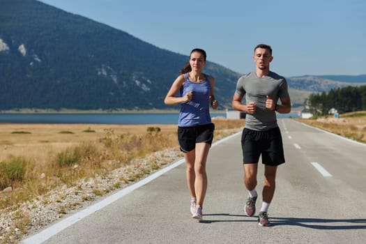 A couple runs through a sun-dappled road, their bodies strong and healthy, their love for each other and the outdoors evident in every stride.