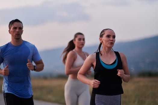 A diverse group of runners finds motivation and inspiration in each other as they train together for an upcoming competition, set against a breathtaking sunset backdrop.