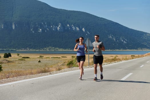 A couple runs through a sun-dappled road, their bodies strong and healthy, their love for each other and the outdoors evident in every stride.