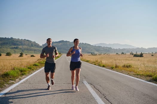 A couple runs through a sun-dappled road, their bodies strong and healthy, their love for each other and the outdoors evident in every stride.