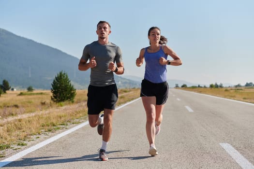 A couple runs through a sun-dappled road, their bodies strong and healthy, their love for each other and the outdoors evident in every stride.