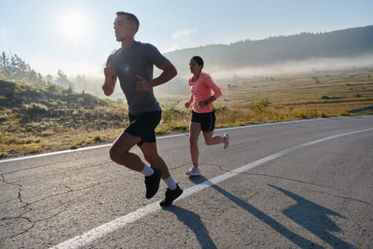 A couple runs through a sun-dappled road, their bodies strong and healthy, their love for each other and the outdoors evident in every stride.