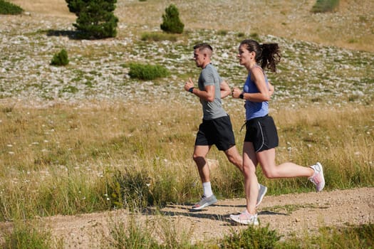 A vibrant couple dashes running the outdoors, embodying the essence of athleticism and romance, their confident strides reflecting a shared commitment to fitness and preparation for future marathon challenges.