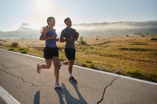 A couple runs through a sun-dappled road, their bodies strong and healthy, their love for each other and the outdoors evident in every stride.