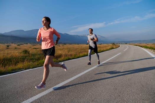 A couple runs through a sun-dappled road, their bodies strong and healthy, their love for each other and the outdoors evident in every stride.