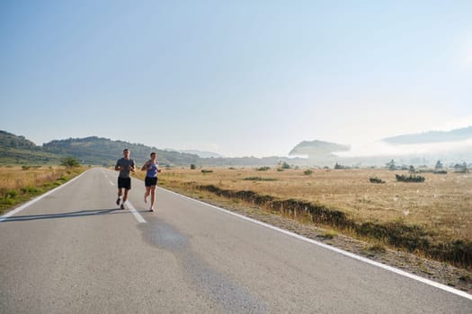 A couple runs through a sun-dappled road, their bodies strong and healthy, their love for each other and the outdoors evident in every stride.