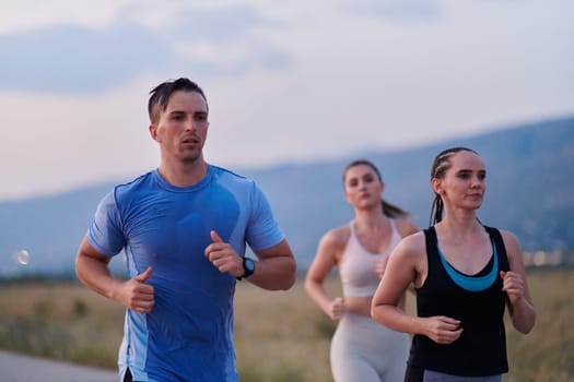 A diverse group of runners finds motivation and inspiration in each other as they train together for an upcoming competition, set against a breathtaking sunset backdrop.