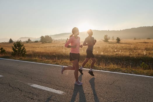 A couple runs through a sun-dappled road, their bodies strong and healthy, their love for each other and the outdoors evident in every stride.