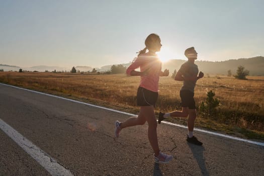 A couple runs through a sun-dappled road, their bodies strong and healthy, their love for each other and the outdoors evident in every stride.