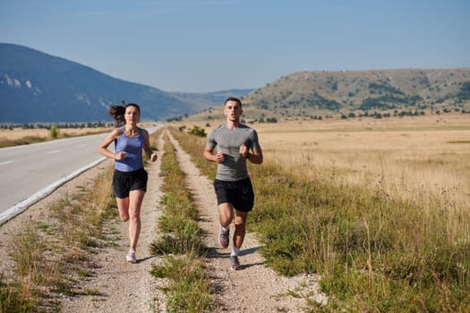 A couple runs through a sun-dappled road, their bodies strong and healthy, their love for each other and the outdoors evident in every stride.