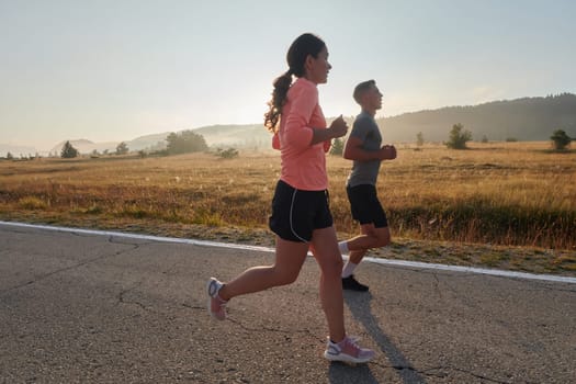 A couple runs through a sun-dappled road, their bodies strong and healthy, their love for each other and the outdoors evident in every stride.