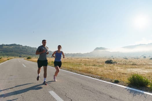 A couple runs through a sun-dappled road, their bodies strong and healthy, their love for each other and the outdoors evident in every stride.