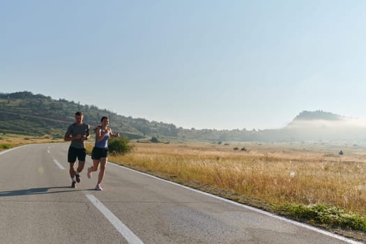 A couple runs through a sun-dappled road, their bodies strong and healthy, their love for each other and the outdoors evident in every stride.