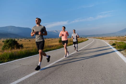 A group of friends maintains a healthy lifestyle by running outdoors on a sunny day, bonding over fitness and enjoying the energizing effects of exercise and nature.