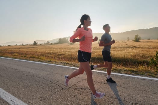 A couple runs through a sun-dappled road, their bodies strong and healthy, their love for each other and the outdoors evident in every stride.