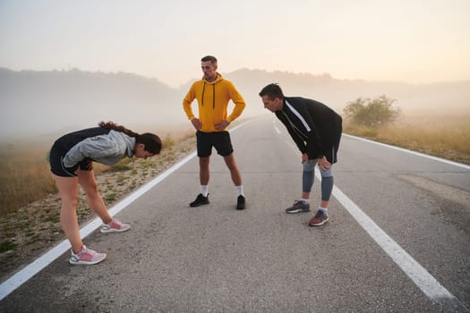 In a dynamic display of unity and preparation, a diverse group of athletes warm up together, readying themselves for a challenging running endeavor.