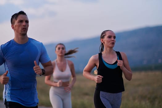 A diverse group of runners finds motivation and inspiration in each other as they train together for an upcoming competition, set against a breathtaking sunset backdrop.