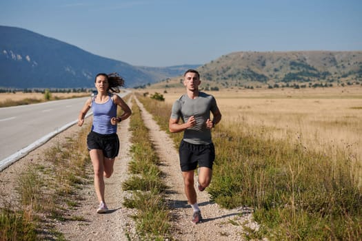 A couple runs through a sun-dappled road, their bodies strong and healthy, their love for each other and the outdoors evident in every stride.