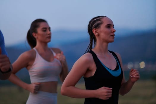 A diverse group of runners finds motivation and inspiration in each other as they train together for an upcoming competition, set against a breathtaking sunset backdrop.