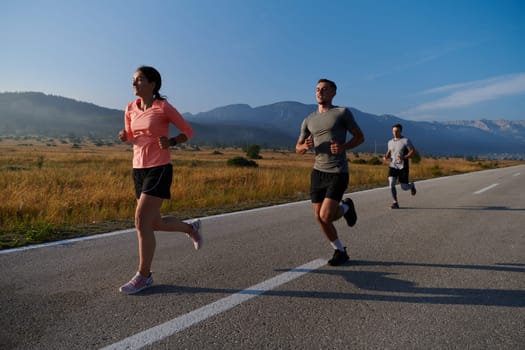 A group of friends maintains a healthy lifestyle by running outdoors on a sunny day, bonding over fitness and enjoying the energizing effects of exercise and nature.