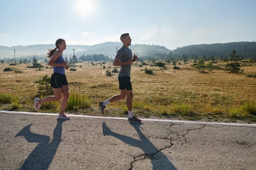 A couple runs through a sun-dappled road, their bodies strong and healthy, their love for each other and the outdoors evident in every stride.