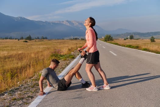 As dawn breaks, a romantic couple engages in a gentle stretch together, symbolizing their shared dedication and preparation for an invigorating early morning run.